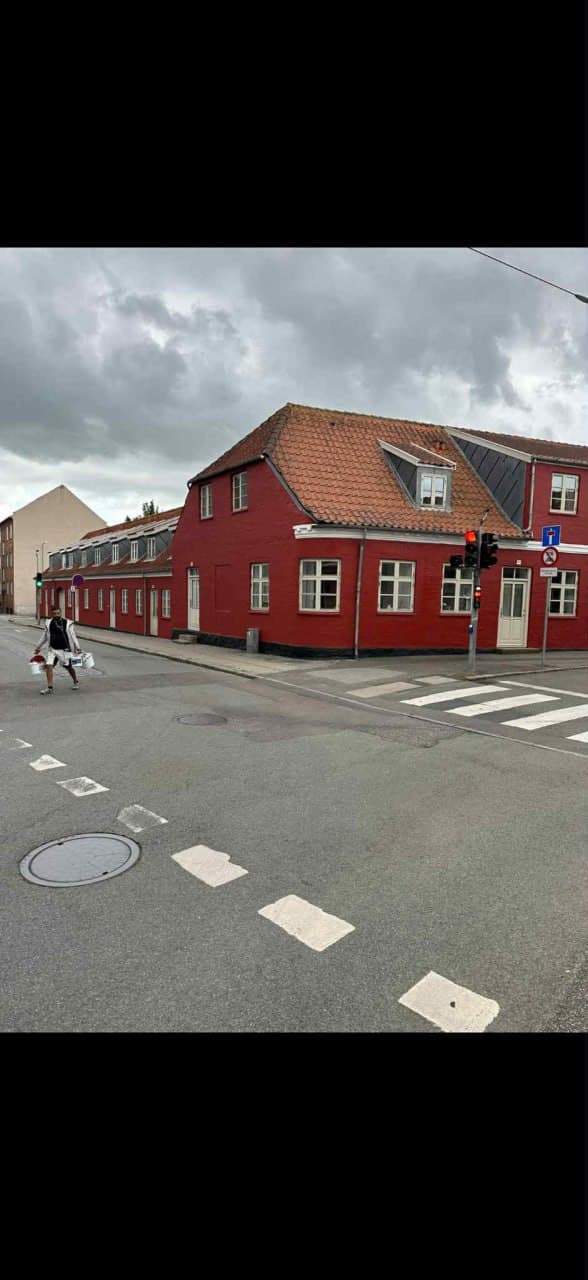 Rød bygning i bybillede — udvendig facademaling udført af Schou & Christensen