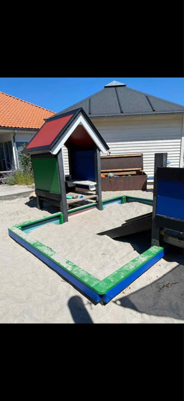 Sandkasse og legehus malet i farver — udvendig maling af børneinstitution